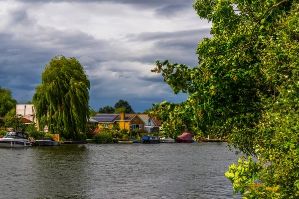 Large rivière et maisons sur le rivage, bateaux amarrés, végétati vert — Photo