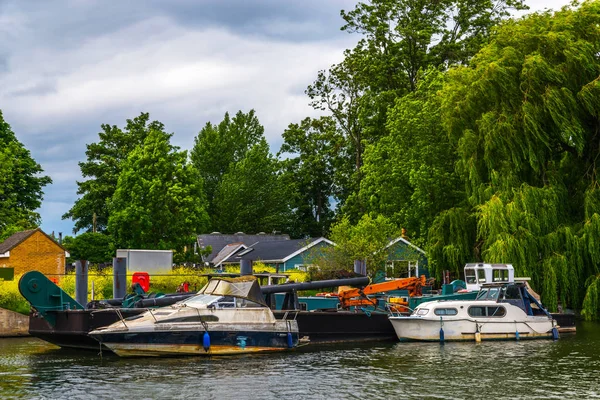 Szerokiej rzeki i domy na brzegu, zacumowane łodzie, zielony rośli — Zdjęcie stockowe