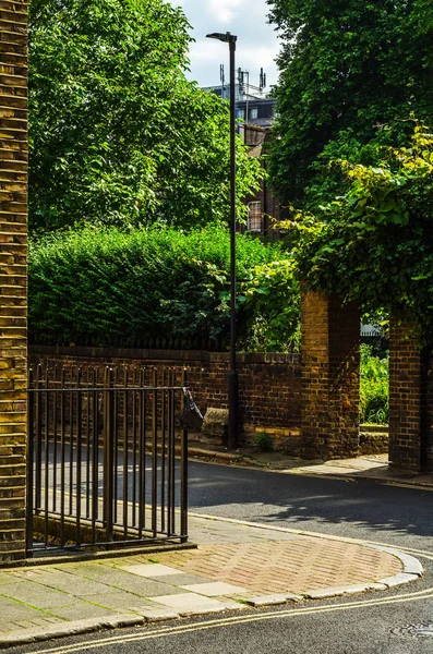 Typical old English buildings, low brick buildings across a narr