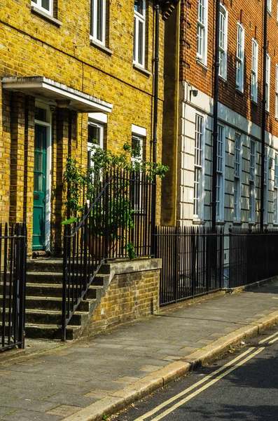 Typical old English buildings, low brick buildings across a narr