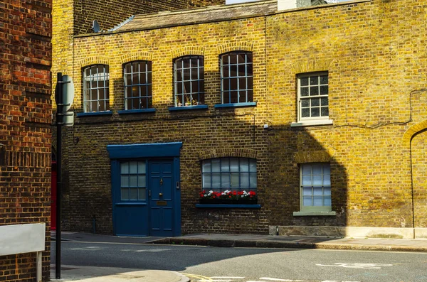 Edifícios ingleses velhos típicos, edifícios baixos do tijolo através de um narr — Fotografia de Stock