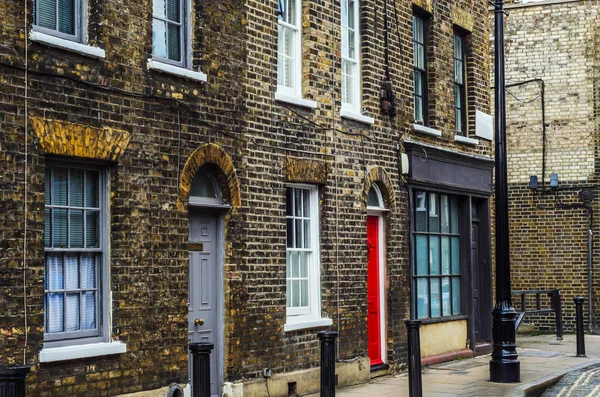 Edifícios ingleses velhos típicos, edifícios baixos do tijolo através de um narr — Fotografia de Stock