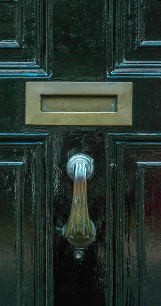 Porta com batedor de latão na forma de uma mão, bela entrada — Fotografia de Stock