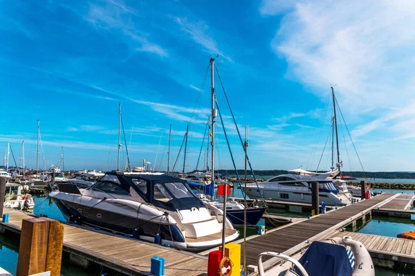 Boats anchored in a small harbor, in the background stone promen