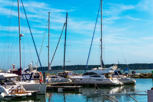 Boats anchored in a small harbor, in the background stone promen