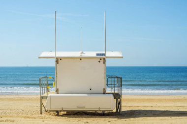 Beyaz kurtarma kulübe güvenli bir kumlu plajda sakin okyanus ile bir olmak