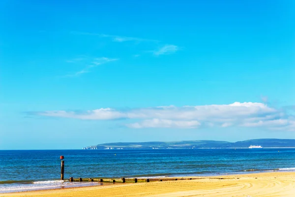 Pali di pontile su una spiaggia sabbiosa, oceano blu e sabbia gialla, soleggiato — Foto Stock