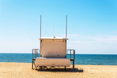 Beyaz kurtarma kulübe güvenli bir kumlu plajda sakin okyanus ile bir olmak