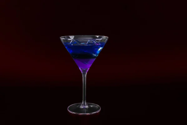 Bebida colorida em um copo de coquetel, com cubos de gelo, bebida de verão — Fotografia de Stock