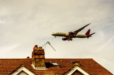 Konut evleri, düşük çatılarda uçan yolcu uçağı 