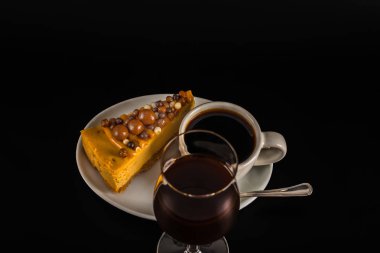 Beyaz sauc üzerinde cheesecake ile beyaz fincan aromalı siyah kahve