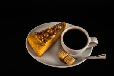 Beyaz sauc üzerinde cheesecake ile beyaz fincan aromalı siyah kahve