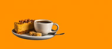 Beyaz sauc üzerinde cheesecake ile beyaz fincan aromalı siyah kahve