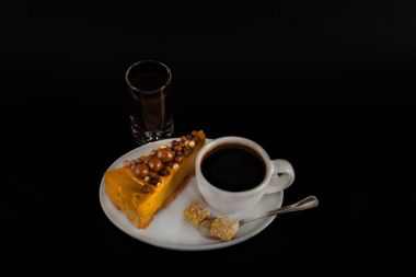 Beyaz sauc üzerinde cheesecake ile beyaz fincan aromalı siyah kahve