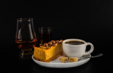 Beyaz sauc üzerinde cheesecake ile beyaz fincan aromalı siyah kahve