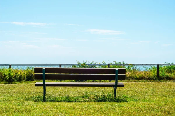 Tomma bänken på en kulle vid havet stranden, gröna lummiga växtlighet, — Stockfoto
