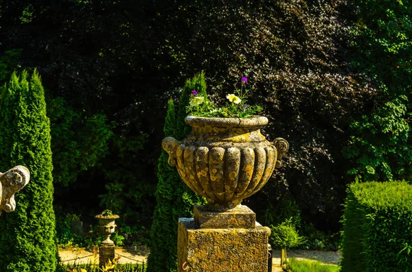 Betonowe donice w ogrodzie na piedestale stylizowane antiqu — Zdjęcie stockowe