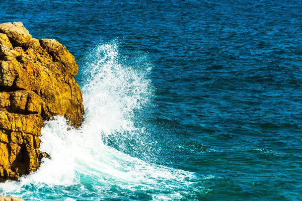 Висока скеля над морем, літній морський фон, багато бризок — стокове фото