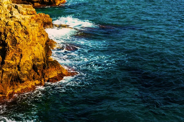 Alto acantilado sobre el mar, fondo de mar de verano, muchas salpicaduras — Foto de Stock