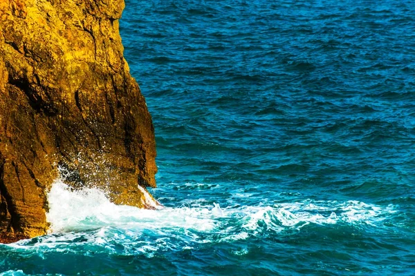 Haute falaise au-dessus de la mer, fond marin d'été, de nombreuses éclaboussures — Photo