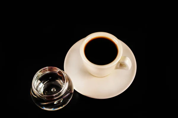 Schwarzer Kaffee in der weißen Tasse und ein Glas Sambuca mit Kaffee — Stockfoto