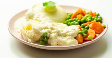 Krem peynir soslu balık fileto, patates püresi, bezelye ve havuç, geleneksel İngiliz yemeği.