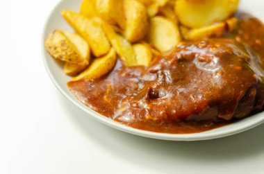 Izgara soslu ızgara tavuk göğsü fileto füme domuz pastırması ve kırmızı Leicester peyniri ile kaplı ve patates dilimleri ile servis edilen geleneksel İngiliz yemeği.