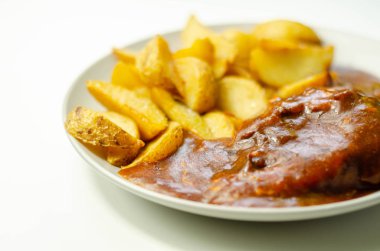 Izgara soslu ızgara tavuk göğsü fileto füme domuz pastırması ve kırmızı Leicester peyniri ile kaplı ve patates dilimleri ile servis edilen geleneksel İngiliz yemeği.