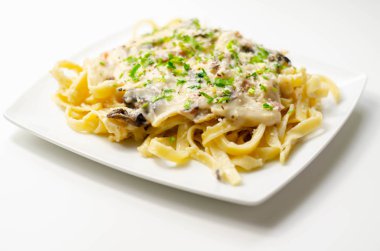 Tagliatelle makarnası, füme jambon ve kızarmış mantar.
