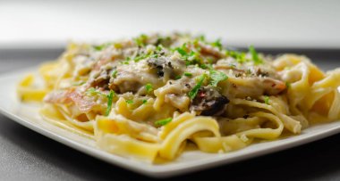 Tagliatelle makarnası, füme jambon ve kızarmış mantar.