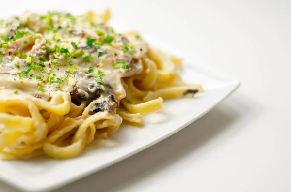 Pasta liatelle с копченой ветчиной и жареными грибами — стоковое фото