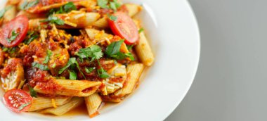 Zengin domates soslu makarna ve İngiliz domuzu dilimleri. 