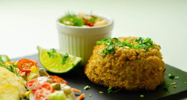 Kızarmış patates dilimleri ve karışık salam ile füme mezgit balığı keki.