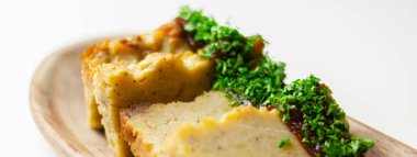 Geleneksel Doğu Avrupa yemekleri olan tahta tabakta soslu ve maydanozlu patates keki.