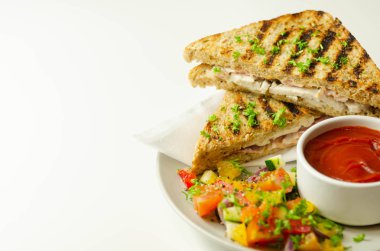 Tavuk göğsü ve kayın ağacı tütsülenmiş pastırmalı el yapımı sandviç. Karışık salata, domates sosu ve sağlıklı bir yemekle servis ediliyor.