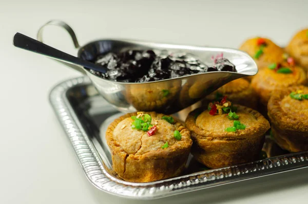 Traditional  English pork pies with cranberry sauce on a silver tray, English food