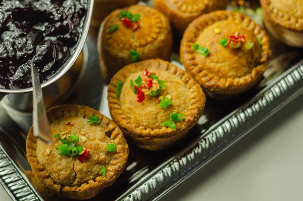 Traditional  English pork pies with cranberry sauce on a silver tray, English food