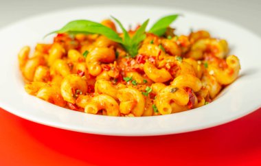 Baharatlı domates ve jalapeno sosuyla pişirilmiş tavuk göğsü ve biberli selentani makarna.