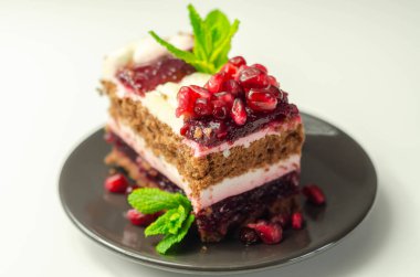 Renkli çok katmanlı kremalı çikolatalı pasta, kiraz reçeli ve nar, lezzetli bir ikram.