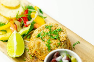 Dilimlenmiş mezgit balığı keki, kızarmış patates, karışık salata, deniz ürünleri.