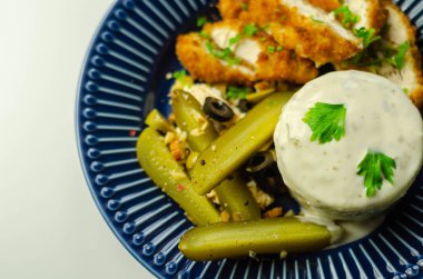 Patates püresi ve zeytinli turşu ile servis edilen kızarmış tavuk göğsü filetosu. Lezzetli yemekler.