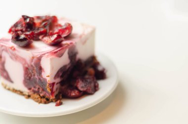 Kiraz soslu Japon peynirli kek ve seramik tabakta taze kiraz ve kırmızı arka plan, tatlı tatlı.