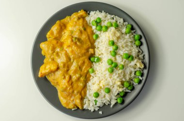 Hafif baharatlı hindistan cevizi soslu tavuk göğsü parçaları bezelye ve yumurtalı pilav ve Hint yemeği.