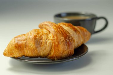 Tabakta enfes kruvasan, fincanda kahve, Fransız kahvaltısı.