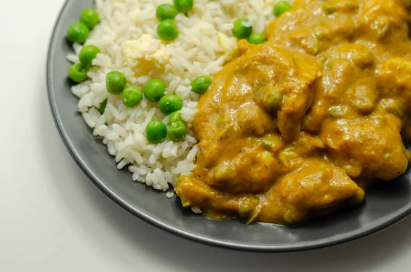 Hafif baharatlı hindistan cevizi soslu tavuk göğsü parçaları bezelye ve yumurtalı pilav ve Hint yemeği.