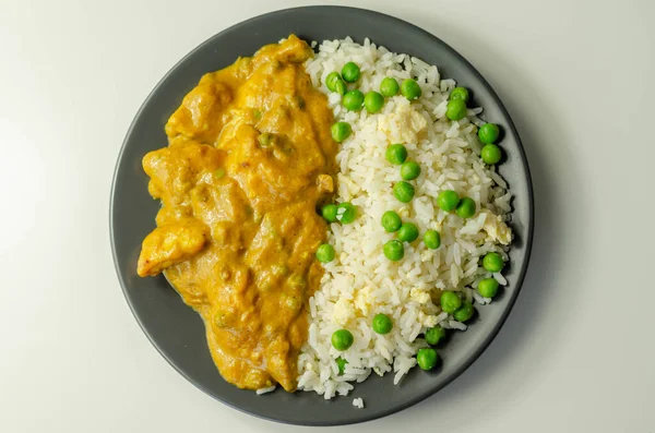 Hafif baharatlı hindistan cevizi soslu tavuk göğsü parçaları bezelye ve yumurtalı pilav ve Hint yemeği.