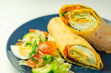 Mozzarella peynirli domates, roket, fesleğen soslu domates dürümü ve salata, lezzetli yemekler.