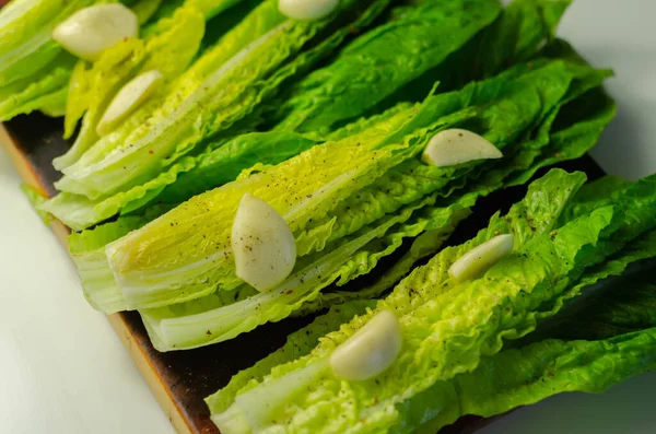 Fresh, cut romaine lettuce with garlic, pepper and salt, meal preparation — Stock Image Fresh Cut Romaine Lettuce Garlic Pepper Salt Meal Preparation Stock Image