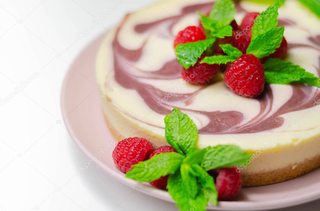 Creamy vanilla baked cheesecake, swirled with raspberry sauce on a biscuit crumb base, summer cake