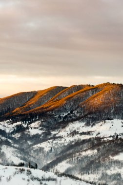 Kış dağ manzaralı şafakta güneş ışınları mounta tepesine Parlatıcı.